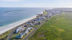 una vista aerea di una spiaggia con case e l'oceano di The Victoria Hotel a Port MacDonnell