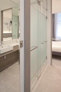 y baño con ducha acristalada y lavamanos. en Heeton Concept Hotel - Kensington London, en Londres