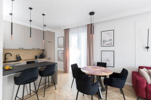 Il comprend une cuisine et un salon avec une table et des chaises. dans l'établissement Apartamenty Par La Mer, à Niechorze