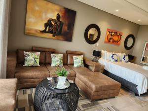 a living room with a couch and a bed at Zimbali Lakes Boulevard Suite 125 in Ballito