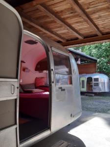 une porte ouverte d'une camionnette garée sous un toit dans l'établissement Airstream Hotel, à Kahla