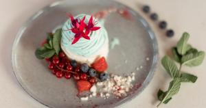 a dessert with berries and whipped cream on a plate at Narva-Jõesuu Medical Spa in Narva-Jõesuu