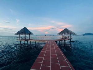 ein Pier im Wasser mit Sonnenschirmen darauf in der Unterkunft Gold Coast Phu Quoc Beach Resort in Phu Quoc