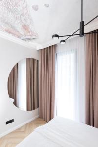 - une chambre avec un lit blanc et un miroir dans l'établissement Apartamenty Par La Mer, à Niechorze
