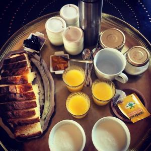 a table with a breakfast of toast and orange juice at Les Cabanes du Vigné in Molandier +10 photos