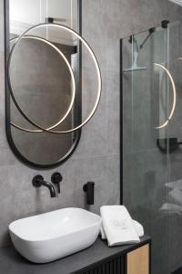 La salle de bains est pourvue d'un lavabo et d'un miroir. dans l'établissement Apartamenty Par La Mer, à Niechorze