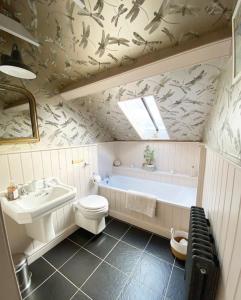 a bathroom with a toilet and a tub and a sink at Lovely 2 bed annexe with open plan living area in Salisbury