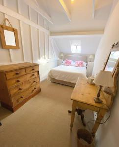a bedroom with a bed and a dresser and a table at Lovely 2 bed annexe near Salisbury in Salisbury