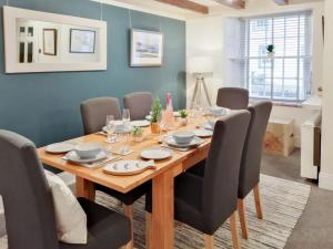 a dining room with a wooden table and chairs at Fisher Gallery in Pittenweem