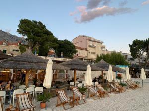 a group of tables and chairs with umbrellas at Villa Rozika in Baška Voda