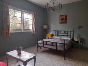 a bedroom with a bed and a table and a window at Boho Hostel in St. Julianʼs