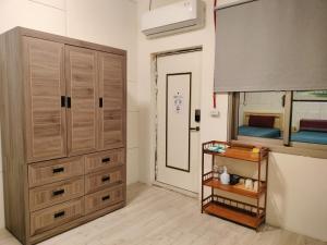 Un dormitorio con un gran armario de madera y un espejo. en 水源棧, en Fengyuan