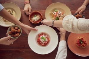 un grupo de personas sentadas alrededor de una mesa comiendo comida en Corte Di Ferro Hotel & Wellness Resort en Carovigno