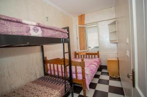 een slaapkamer met 2 stapelbedden en een geruite vloer bij Hostel California in Batoemi