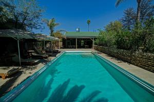 a swimming pool in front of a house at Na’ankusê @ Utopia in Windhoek