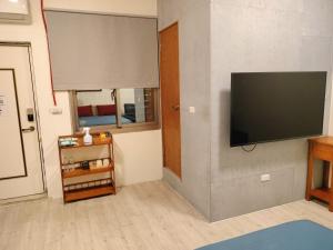 sala de estar con TV de pantalla plana en la pared en 水源棧 en Fengyuan