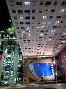 uma vista para um parque de estacionamento com um grande edifício em Comfort 2BR green pramuka bougenvile em Jakarta