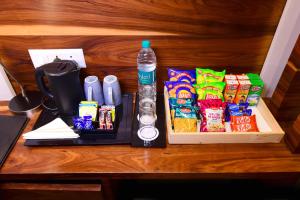 einen Tisch mit einem Tablett mit Snacks und einer Flasche Wasser in der Unterkunft SureStay by Best Western Model Town in Amritsar