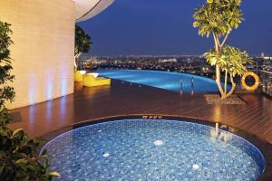 a swimming pool on top of a building with a city at Hotel Ciputra World Surabaya managed by Swiss-Belhotel International in Surabaya