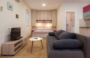 a living room with a couch and a bed at Apartmani Vito i Cvita in Makarska