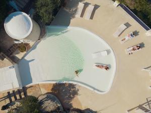 widok na basen z osobami na plaży w obiekcie Corte Di Ferro Hotel & Wellness Resort w mieście Carovigno