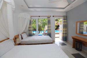 um quarto com 2 camas e uma varanda em MAY Bungalow em Mui Ne
