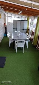 - une table et des chaises dans une pièce dotée d'une moquette verte dans l'établissement mh 4 chambres au calme Bois Dormant, à Saint-Jean-de-Monts