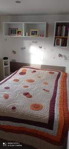 a bed with a quilt on it in a bedroom at mh 4 chambres au calme Bois Dormant in Saint-Jean-de-Monts
