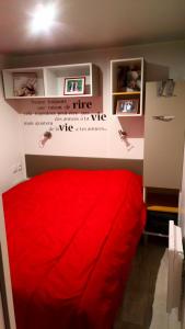 - un lit rouge dans une chambre avec un mur dans l'établissement mh 4 chambres au calme Bois Dormant, à Saint-Jean-de-Monts