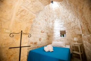 ein Schlafzimmer mit einem blauen Bett in einer Steinmauer in der Unterkunft Pietre Bianche in Carovigno