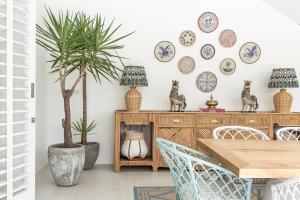 a dining room with a table and chairs and plates on the wall at Umbala the house in Canggu