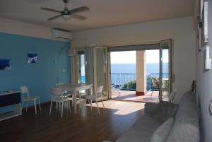 a living room with a couch and a table and chairs at Casa Il Delfino in Aci Castello