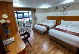 a hotel room with two beds and a table at 456 Hotel in Baguio
