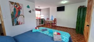 a living room with a blue bed and a kitchen at Henua Roa Loft in Hanga Roa