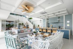 a living room with blue and white furniture and a ceiling at Umbala the house in Canggu