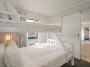 een slaapkamer met 2 stapelbedden en een ladder bij Chill-out Beach Bach - Whangamata Holiday Home in Whangamata