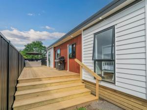 een huis met een houten trap naast een huis bij Chill-out Beach Bach - Whangamata Holiday Home in Whangamata