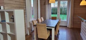 澤沃德的住宿－The Black House - Luxurious Holiday Villa Zeewolde，一间带木桌和椅子的用餐室