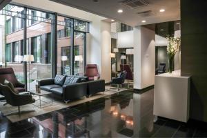 a lobby with couches and chairs in a building at Centennial Nexus Hotel Tallinn in Tallinn