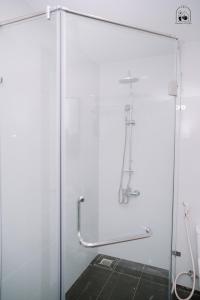 um chuveiro com uma porta de vidro na casa de banho em Chi's Homestay & Coffee em Hue