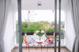 een balkon met 2 stoelen en een tafel bij Chi's Homestay & Coffee in Hue