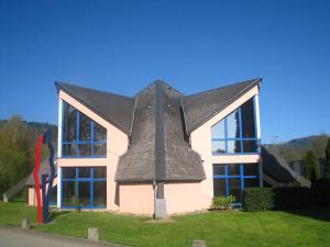 a house with a gray roof on top of it at Résidence la Pyramide in Oberhaslach