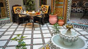 a room with a table and chairs and a tile floor at Riad Green House in Fès