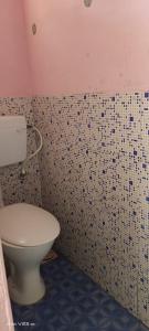 baño con aseo y pared de azulejos en Munnar Home Stay en Munnar