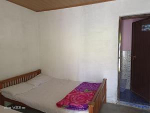 a bedroom with a bed with a purple blanket on it at Munnar Home Stay in Munnar