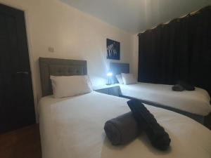 two beds in a hotel room with at Luxury 5 - Spacious Contractor's Delight with 4 Bedrooms and Ample Driveway Parking in Luton