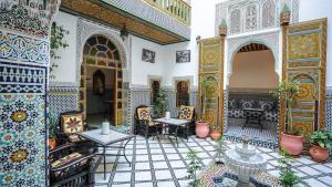 a courtyard of a mosque with tables and chairs at Riad Green House in Fès