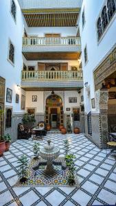 a large courtyard with a fountain in a building at Riad Green House in Fès