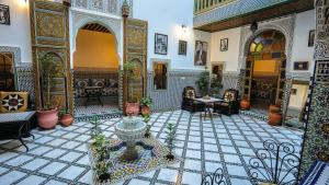 a courtyard with a fountain in the middle of a building at Riad Green House in Fès