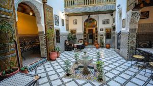 a courtyard with a fountain in the middle of a building at Riad Green House in Fès